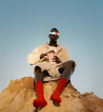 black man on a hill eating popcorn