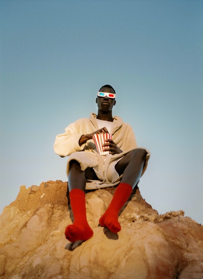 black man on a hill eating popcorn