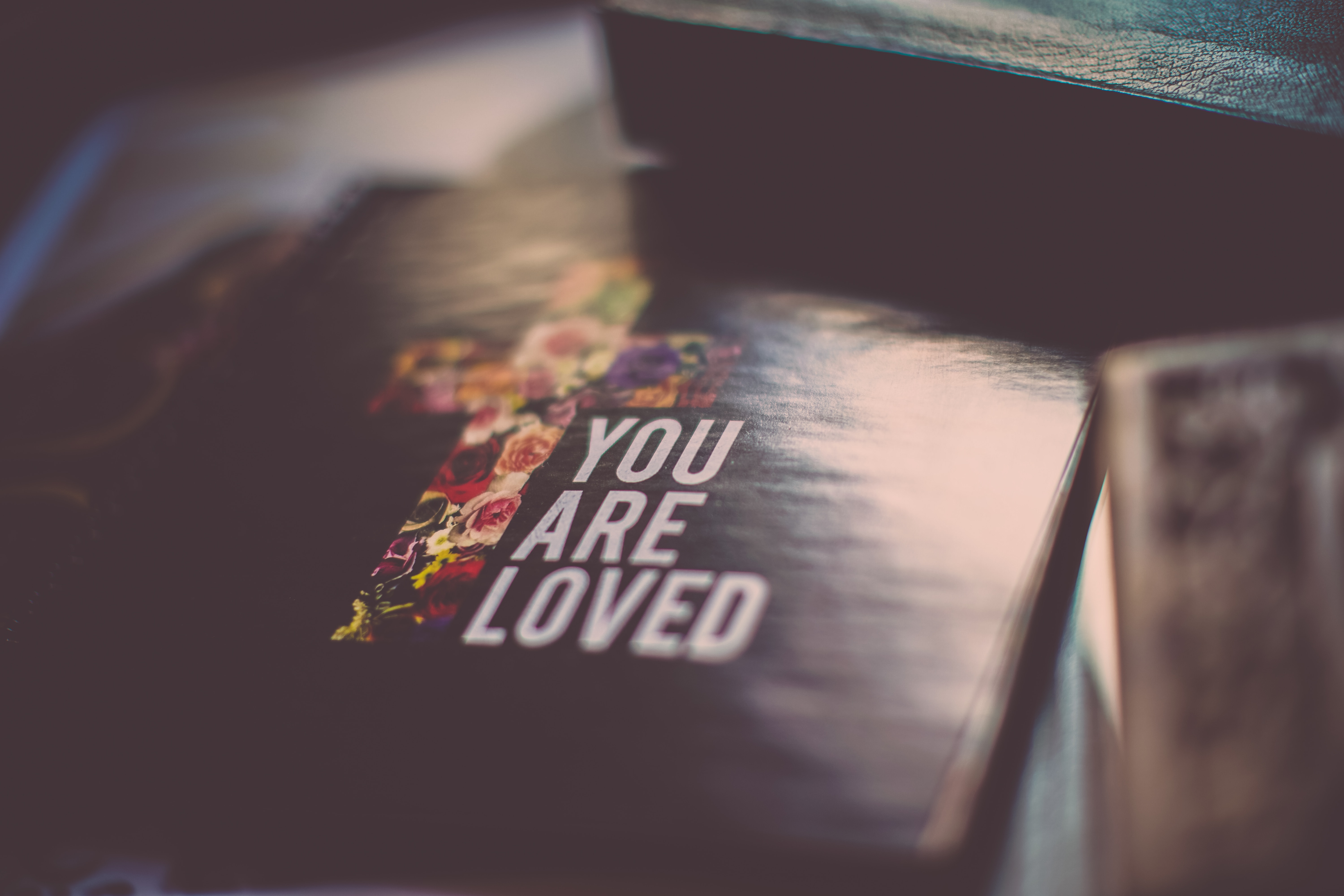selective focus photography of You Are Loved book. Remembering Gods love for us is a helpful way to handle loss.