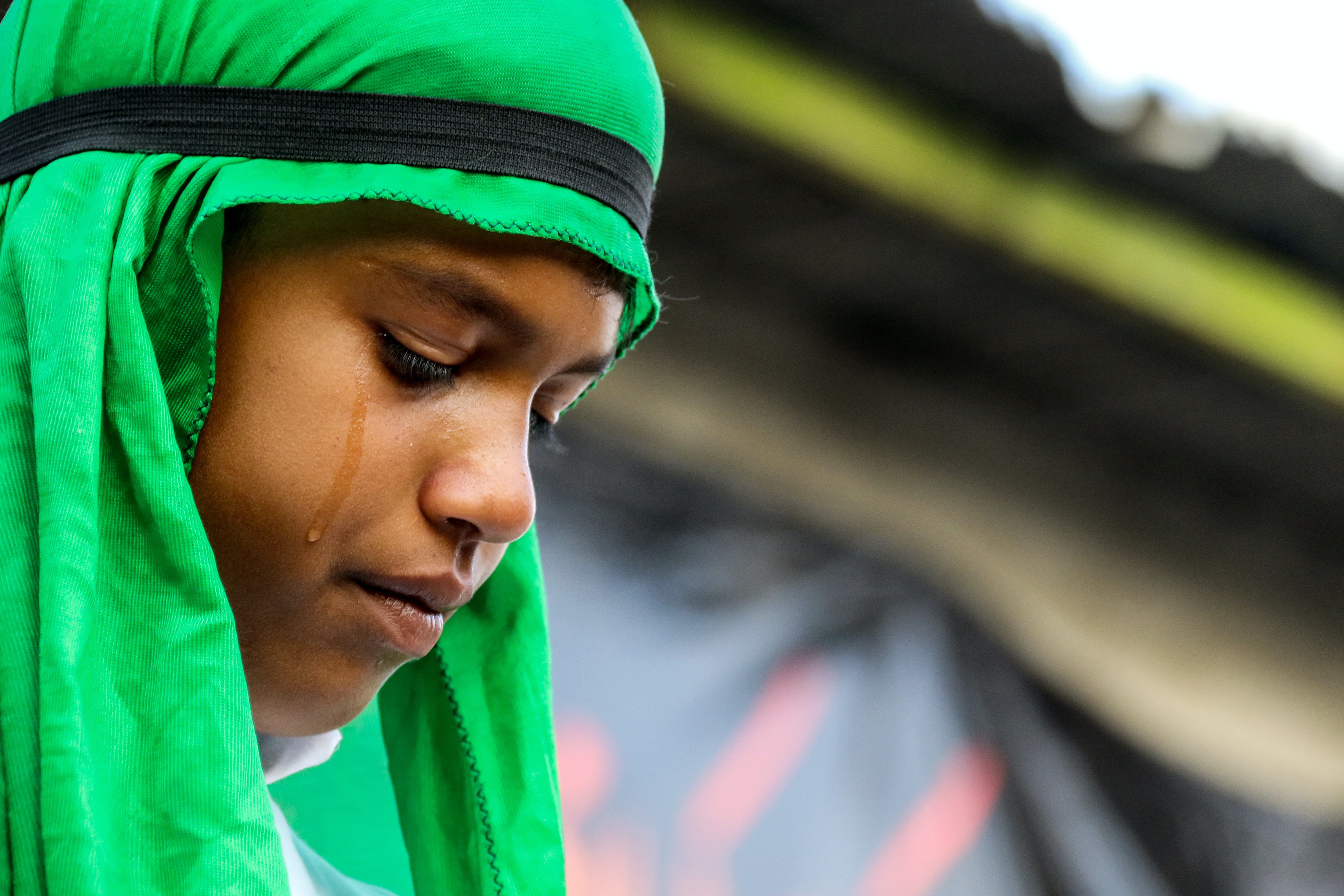 selective focus photo of crying girl wearing green hijab
