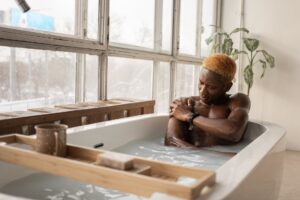black man taking bath in light room